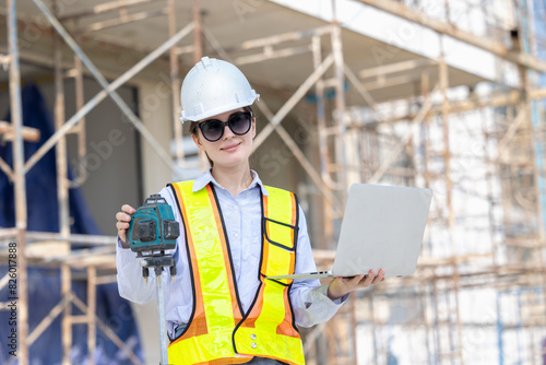 Modern Construction Women Worker Using Laptop and Laser Measurement at Building Site