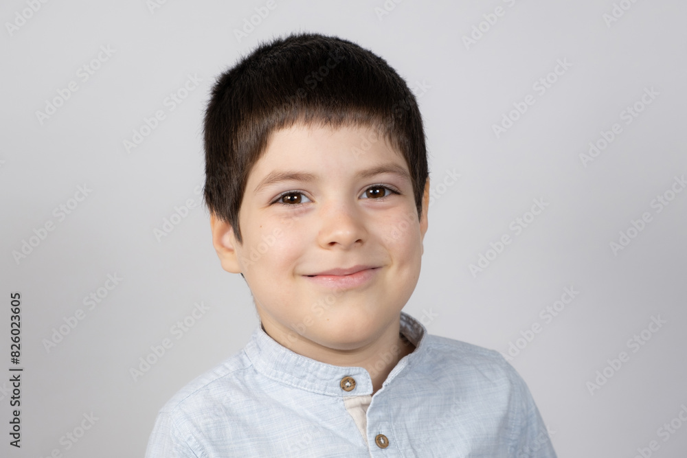 Portrait of a six-year-old European boy on a light gray background. Portrait of a six-year-old European boy on a light gray background.