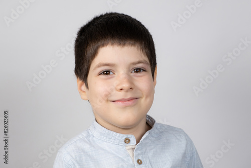 Portrait of a six-year-old European boy on a light gray background.