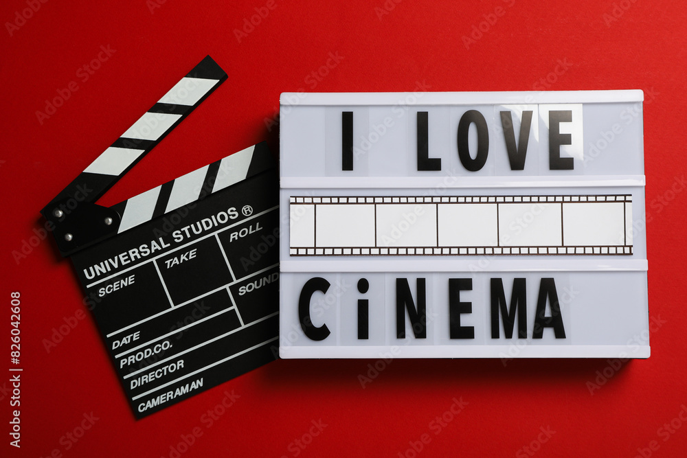 Naklejka premium Light box with text and clapperboard on red background, top view