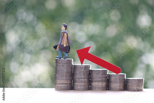 Business man standing on stack of coins money and red arrow graph on natural green background, Business investment and Risk management