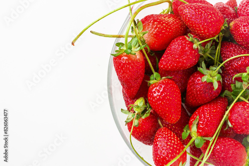 Top view of strawberries in glass bowl on white background