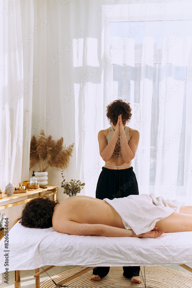 A girl masseuse in a bright, sunny and spacious room giving a massage A girl masseuse in a bright, sunny and spacious room giving a massage