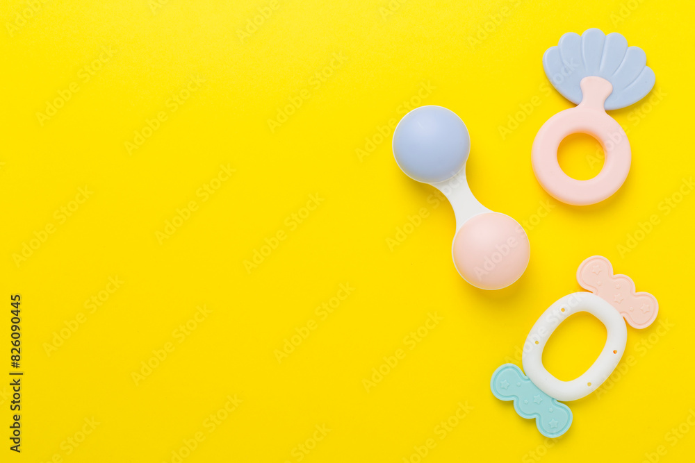 Fototapeta premium Colorful baby rattles and toys on color background, top view