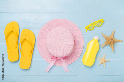 Flat lay with colorful beach accessories on wooden background. Vacation concept