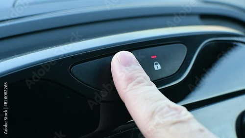 Person turns on a car's hazard warning flasher button, close-up. photo