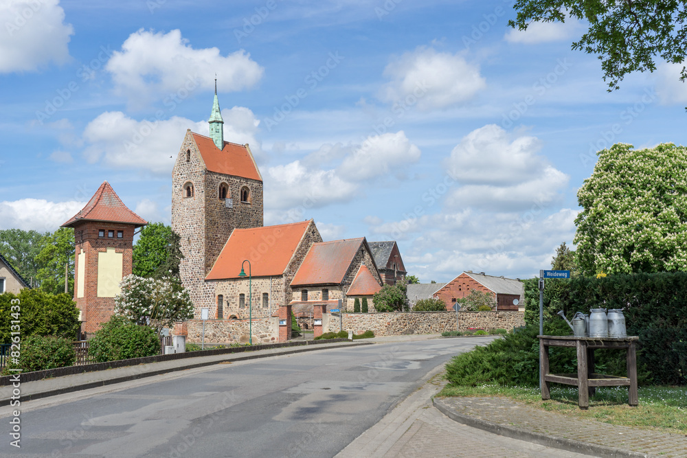 Obraz premium Village street in Groß Schwechten with Romanesque village church made of field stones, Saxony-Anhalt, Germany