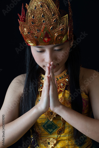 Indonesian Woman in Traditional Golden Attire Praying