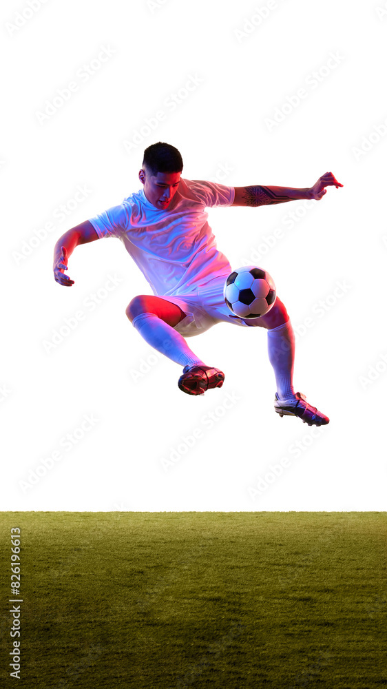 Dynamic shot of young guy dressed sportswear leaping in air to kicks ball in neon light against white studio background. Concept of professionals sport, competition, tournament, energy, action. Ad Dynamic shot of young guy dressed sportswear leaping in air to kicks ball in neon light against white studio background. Concept of professionals sport, competition, tournament, energy, action. Ad