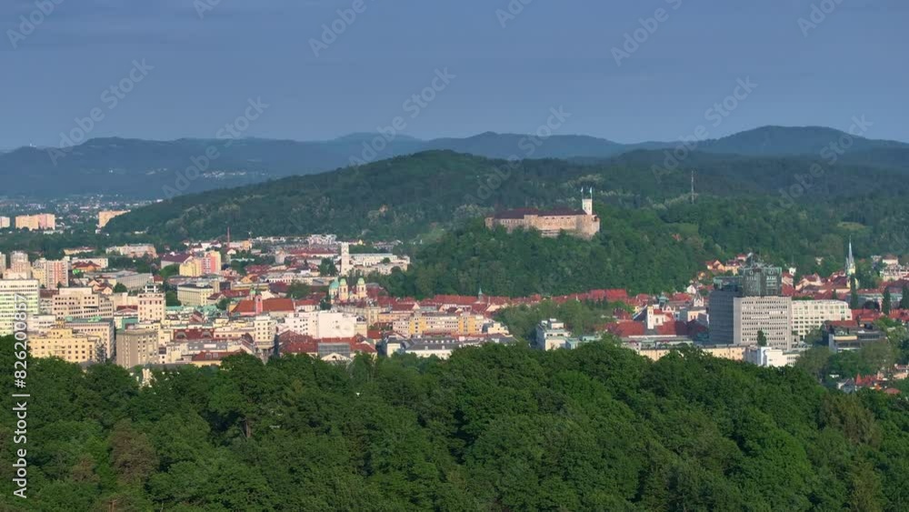 AERIAL: Panoramic view of a quaint European city sprawling underneath a medieval castle. Stunning drone view of a majestic medieval castle overlooking the Ljubljana city center on a sunny spring day. AERIAL: Panoramic view of a quaint European city sprawling underneath a medieval castle. Stunning drone view of a majestic medieval castle overlooking the Ljubljana city center on a sunny spring day.