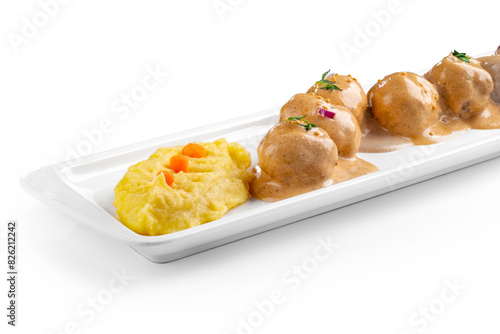 Meat meatballs with mustard sauce and sesame seeds in a white plate isolated on a white background, close up