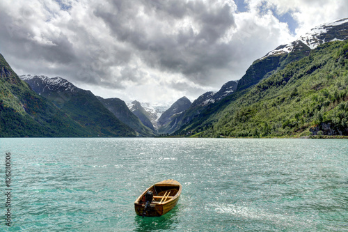 A boat floating in a Lovatnet lake with a mountain view photo