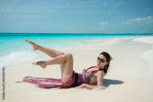 girl in a dress lies on white sand, beach in Cuba, Caribbean sea, palm trees on the beach, ocean shore