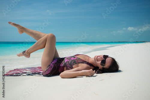 girl in a dress lies on white sand, beach in Cuba, Caribbean sea, palm trees on the beach, ocean shore