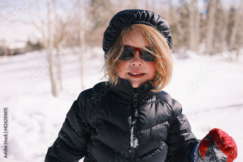 Child enjoying winter day in snowy outdoor landscape