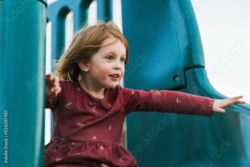 Little girl joyfully playing on a slide at the playground