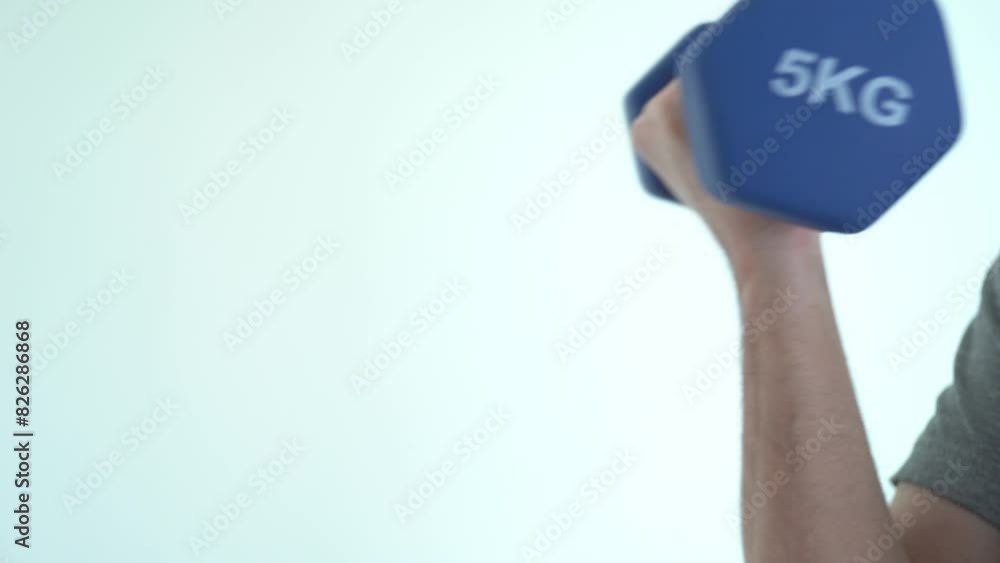 Arm lifting a blue 5kg dumbbell against a white background Arm lifting a blue 5kg dumbbell against a white background