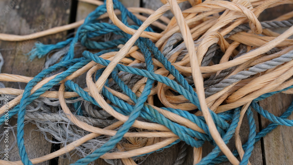 Closeup shot of messy rope and string entangled on a wooden surface Closeup shot of messy rope and string entangled on a wooden surface