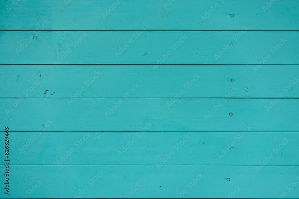 the door of an old wooden blue door in front of a wall with stains the door of an old wooden blue door in front of a wall with stains