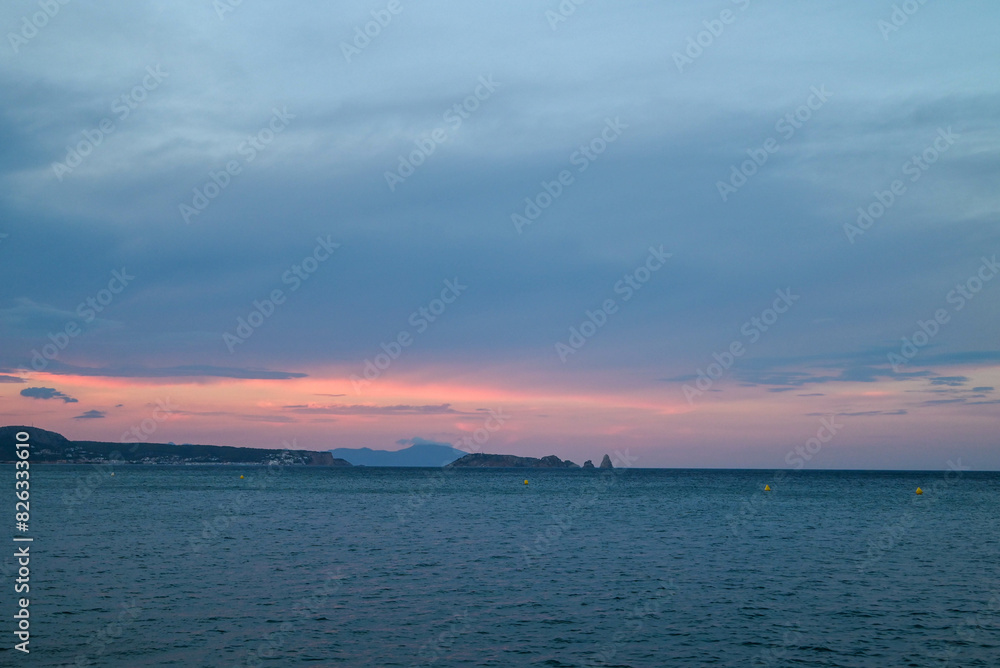Sunset over the serene waters of the Mediterranean coast. Costa Brava, Spain Sunset over the serene waters of the Mediterranean coast. Costa Brava, Spain