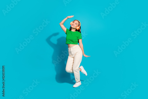 Full body portrait of pretty young girl dance headphones wear t-shirt isolated on turquoise color background