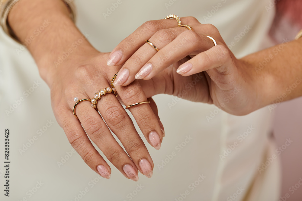A indian womans hands adorned with various rings, reflecting light and showcasing unique designs.
