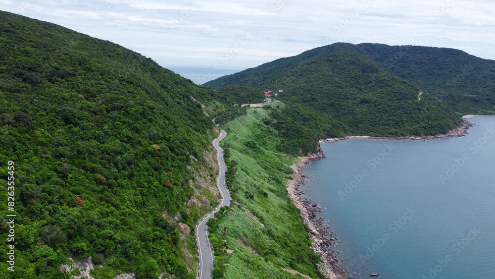 Aerial view of countryside road passing through the green forest and mountain Aerial view of countryside road passing through the green forest and mountain