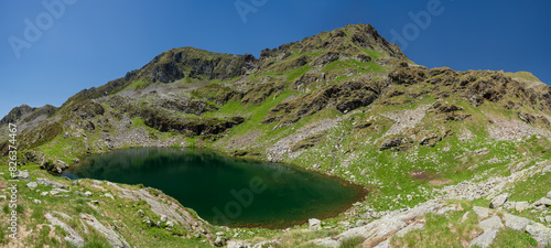 Wide panoramic view of Capezzone lake and mountain, in Strona valley, Piemonte, northern Italy, during a clear day with blue sky. photo