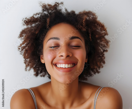 Joyful Young African American Woman with Natural Curly Hair Smiling with Eyes Closed