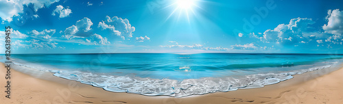 A beautiful beach with clear blue water  white clouds  and bright sun shining on the calm ocean. Perfect for summer vacation and travel poster designs.