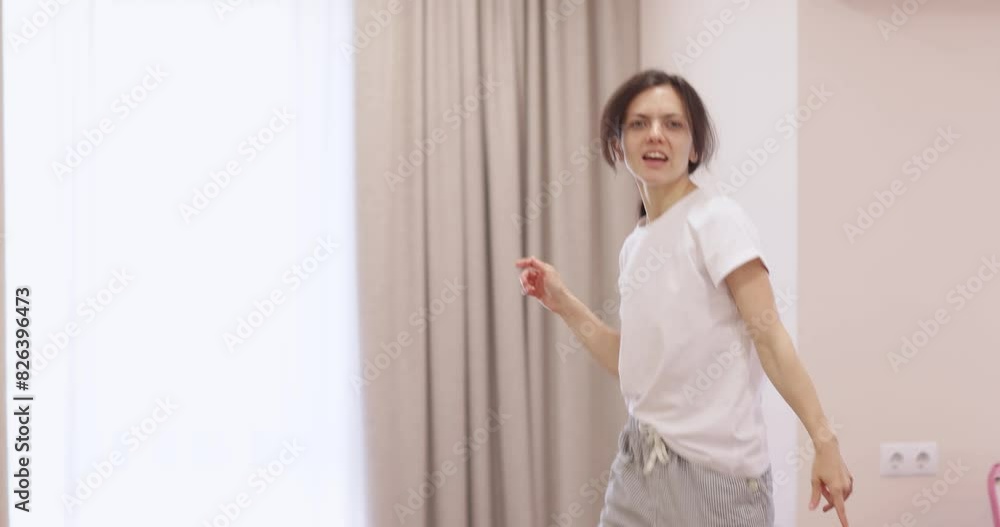 Excited caucasian woman dancing and singing a song in living room at home Excited caucasian woman dancing and singing a song in living room at home