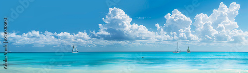 Panoramic view of a turquoise ocean with distant sailboats and white clouds. This scene would be perfect for a summer vacation and travel poster design.