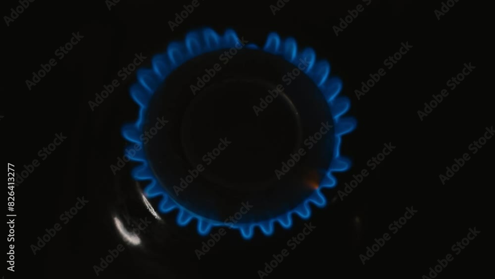 Blue flames of gas stove in the dark firing up Blue flames of gas stove in the dark firing up