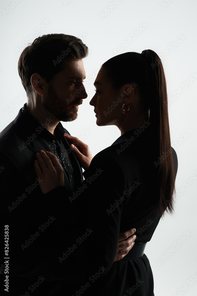 A man and woman, dressed in elegant attire, stand together in a loving pose. A man and woman, dressed in elegant attire, stand together in a loving pose.
