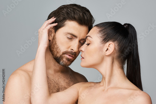 A man and a woman gently touch their foreheads in a gesture of connection and intimacy.