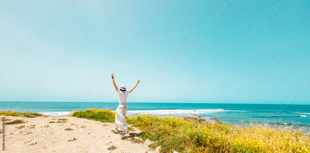 relaxation on the beach. happy girl walks along the beach. A young happy woman in a white dress walks carefree along the seashore. relaxation on the beach. happy girl walks along the beach. A young happy woman in a white dress walks carefree along the seashore.