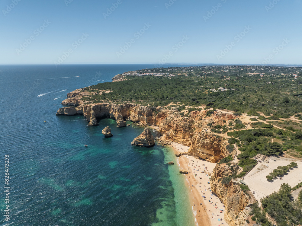 Aerial view of Praia da Marinha beach with rugged cliffs and blue ocean, Algarve region, Portugal. Aerial view of Praia da Marinha beach with rugged cliffs and blue ocean, Algarve region, Portugal.