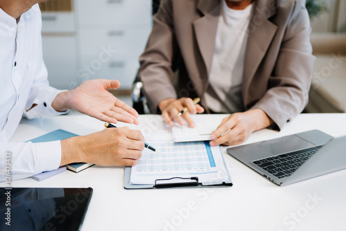 Fototapeta business people and lawyers discussing contract papers sitting at the table