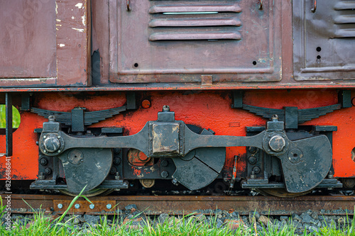 detail of wheels, transmission mechanism and suspensions of an old and small diesel locomotive