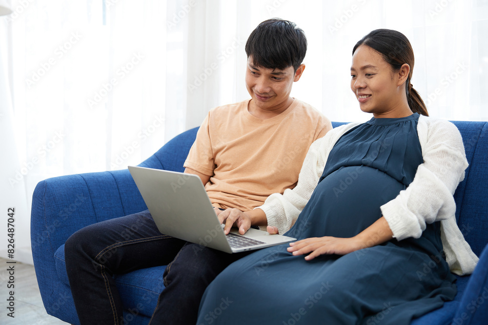 pregnant woman with her husband doing online shopping from laptop computer at home pregnant woman with her husband doing online shopping from laptop computer at home