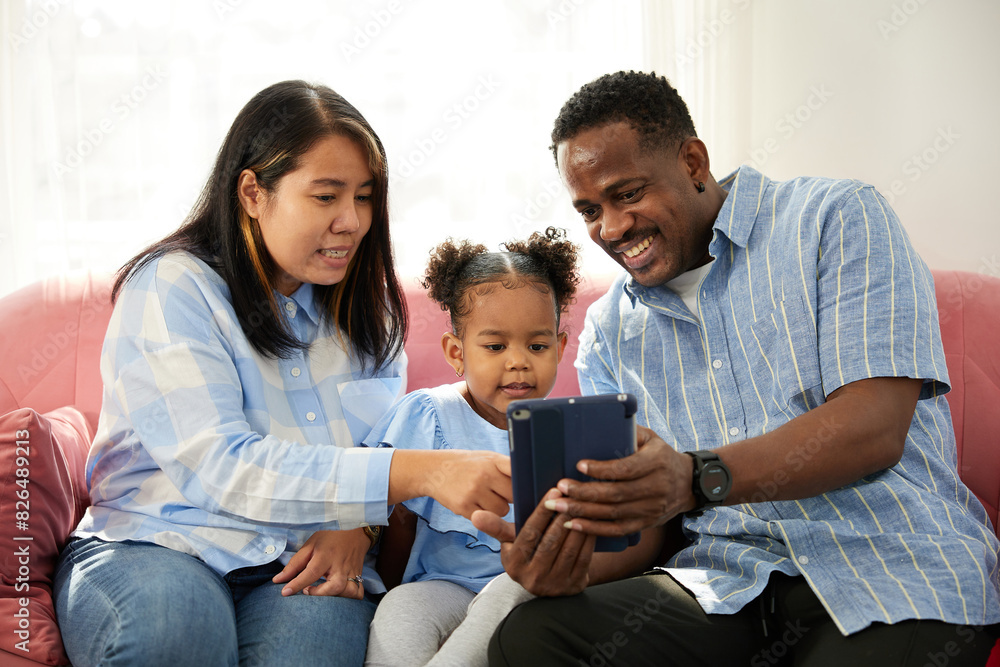mixed race family using tablet online video call and taking selfie on sofa mixed race family using tablet online video call and taking selfie on sofa