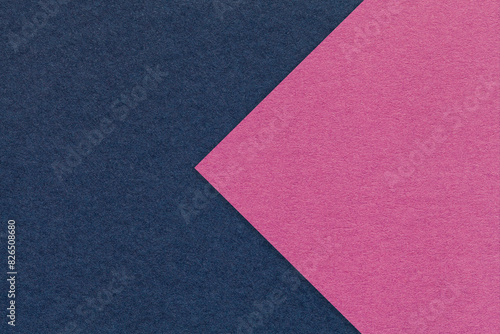 Texture of navy blue paper background, half two colors with purple arrow, macro. Craft magenta cardboard.