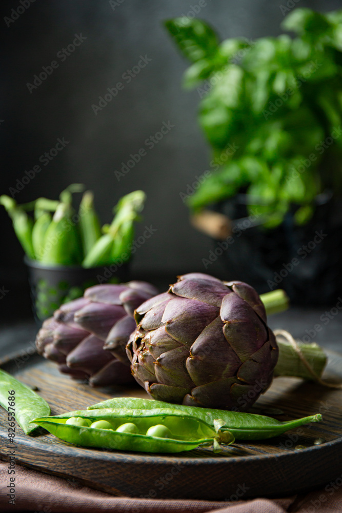 Fototapeta premium Fresh purple artichokes on dark background 