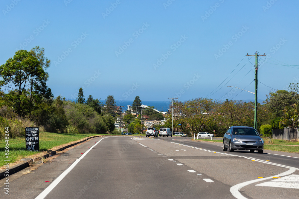 Road to the coast in Redhead area of Newcastle with sea views on horizon Road to the coast in Redhead area of Newcastle with sea views on horizon