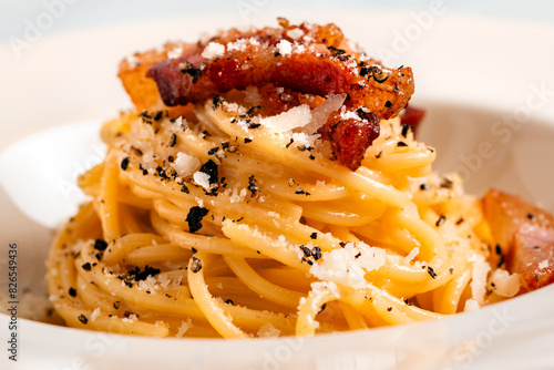 Piatto di saporiti spaghetti alla gricia, tipica ricetta di pasta condita con pecorino, guanciale e pepe nero della cucina Romana, cibo italiano  photo