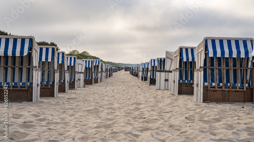 Fototapeta Naklejka Na Ścianę i Meble -  Sandy beach and traditional sun loungers at sunset, Northern Germany, on the Baltic Sea coast. Germany