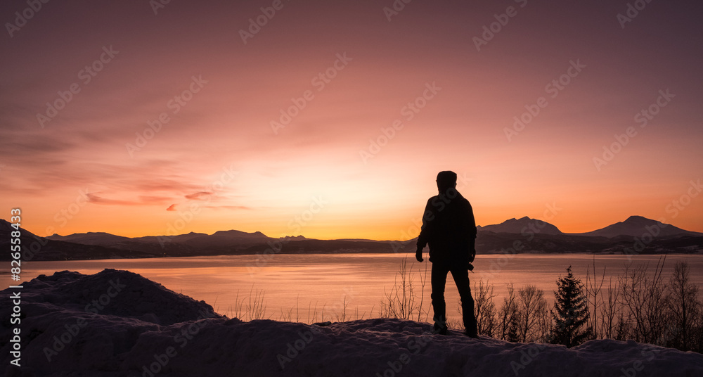 Silhouette of a man at sunset over the Norwegian Fjords Silhouette of a man at sunset over the Norwegian Fjords