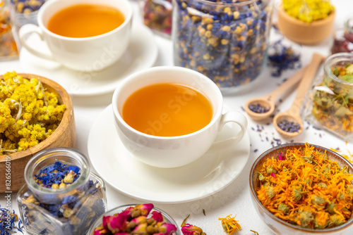 Assortment of dry herbal and berry tea and a cup of tea on a wooden background.Medicinal Healing herbs.Alternative medicine concept.Linden, calendula, cornflowers, marigold, tansy, tea rose.dry herbal