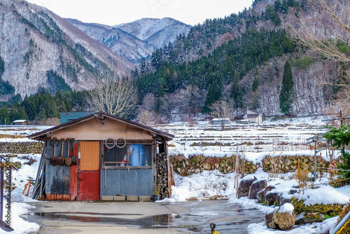 Shirakawa-go in winter, snow falling over the ground, house, historic village in valley, Japan.