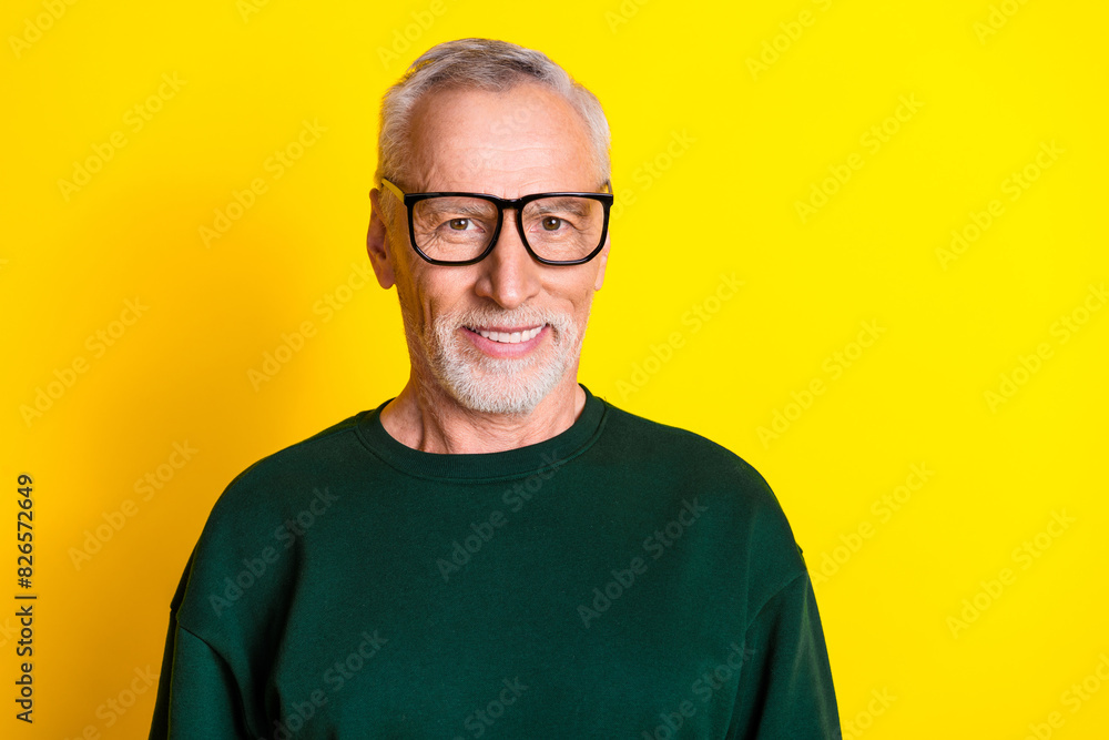 Photo portrait of handsome retired man look camera specs smile wear trendy green outfit isolated on yellow color background Photo portrait of handsome retired man look camera specs smile wear trendy green outfit isolated on yellow color background